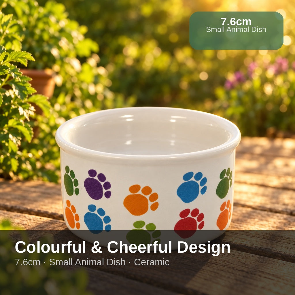 A white ceramic pet bowl decorated with a colorful pattern of paw prints in blue, orange, purple, green, and red, shown.