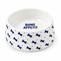 A white ceramic pet bowl with a blue bone and dot pattern on the exterior and the words 'BONE APPETIT' printed inside.